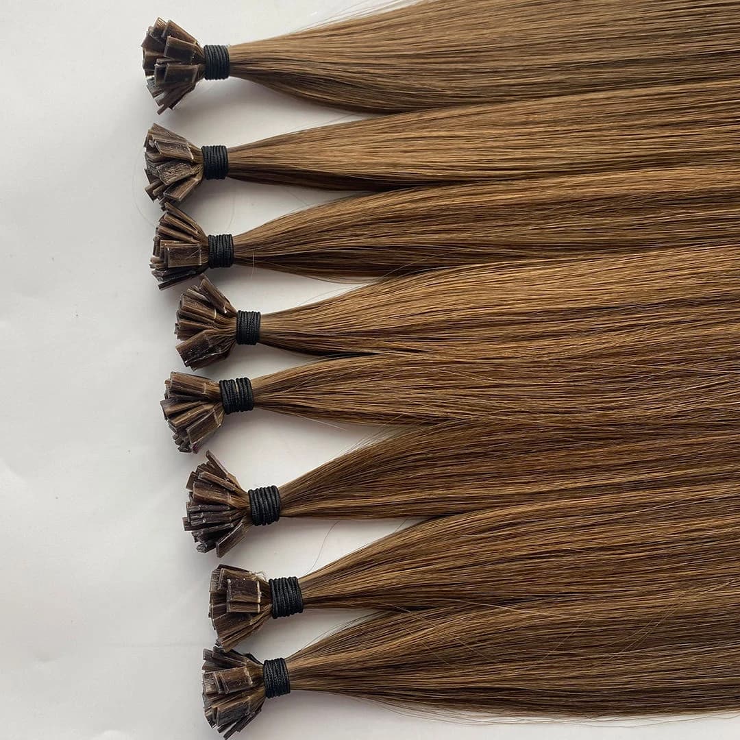 Light brown Flat Tip extension bundles arranged in rows with flat bond ends secured by black ties