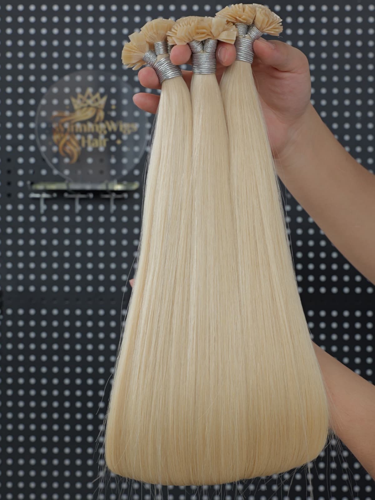Light blonde Flat Tip human hair extension bundles in a studio display