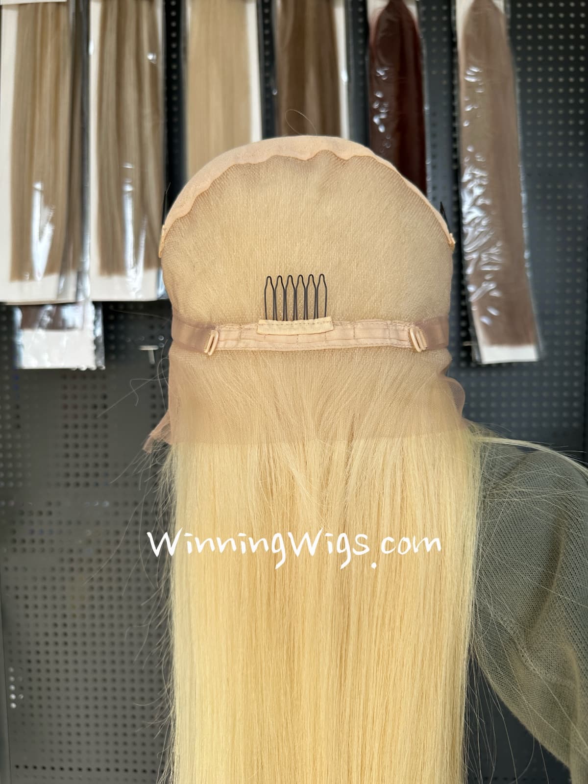 Back interior of a blonde full lace virgin human hair wig showing adjustable straps and comb