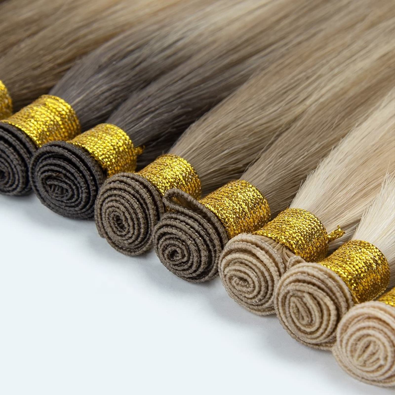 Hand-Tied Weft human hair extension bundles in a natural brown to blonde color range