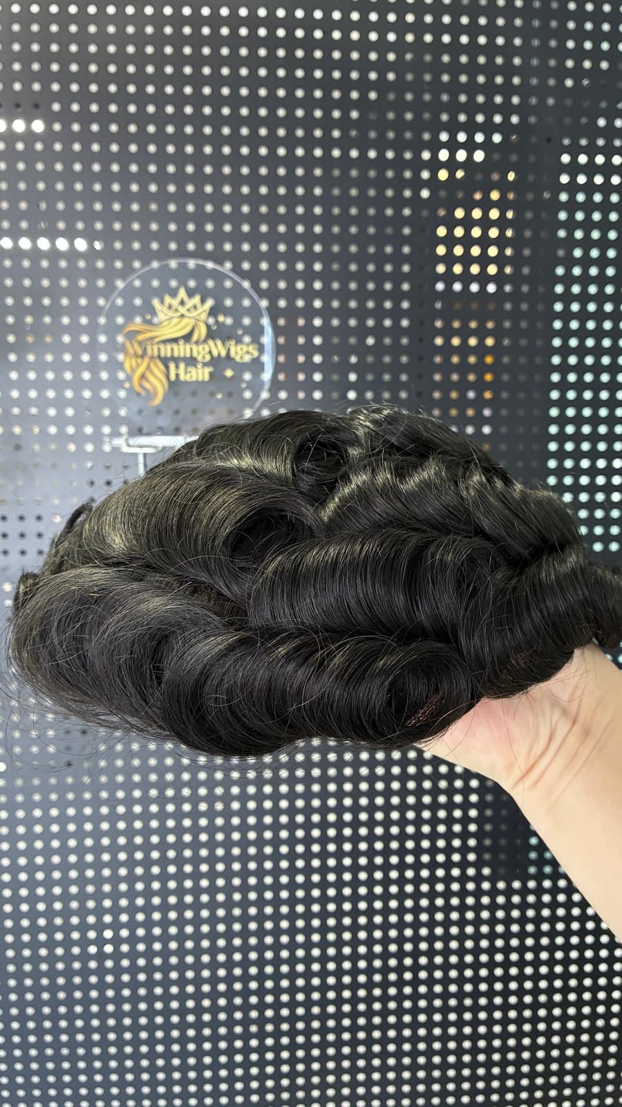 Black wavy men's hair system shown in a studio product view