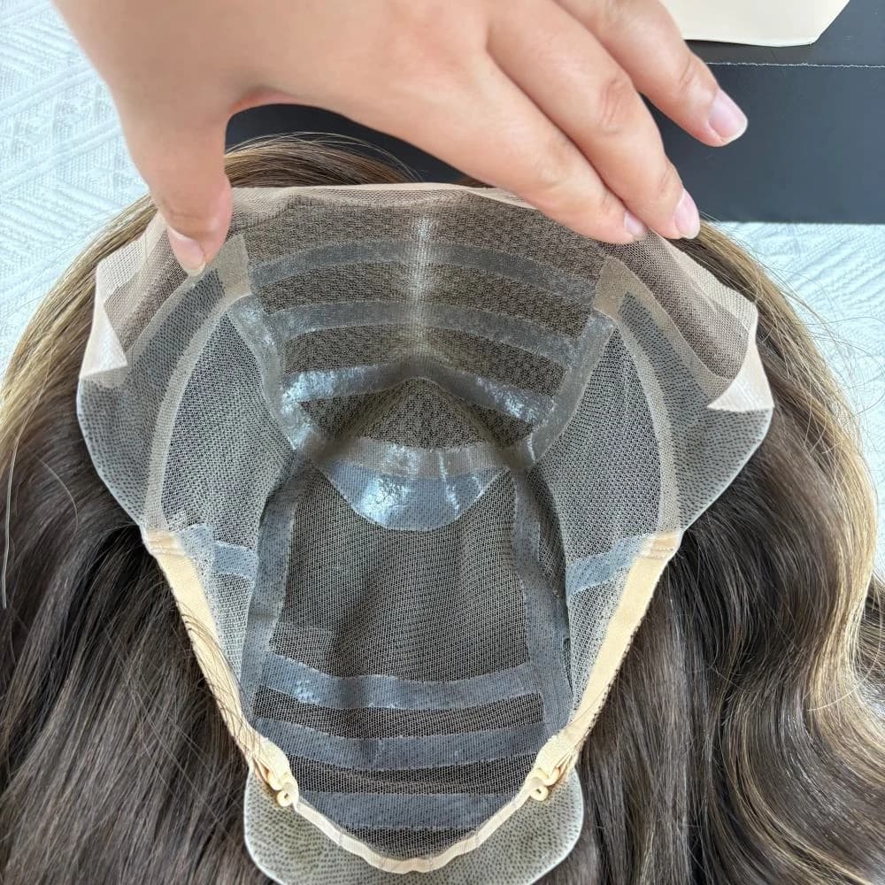 Interior of a wig cap held open, showing mesh panels, horizontal bands and beige adjustment details