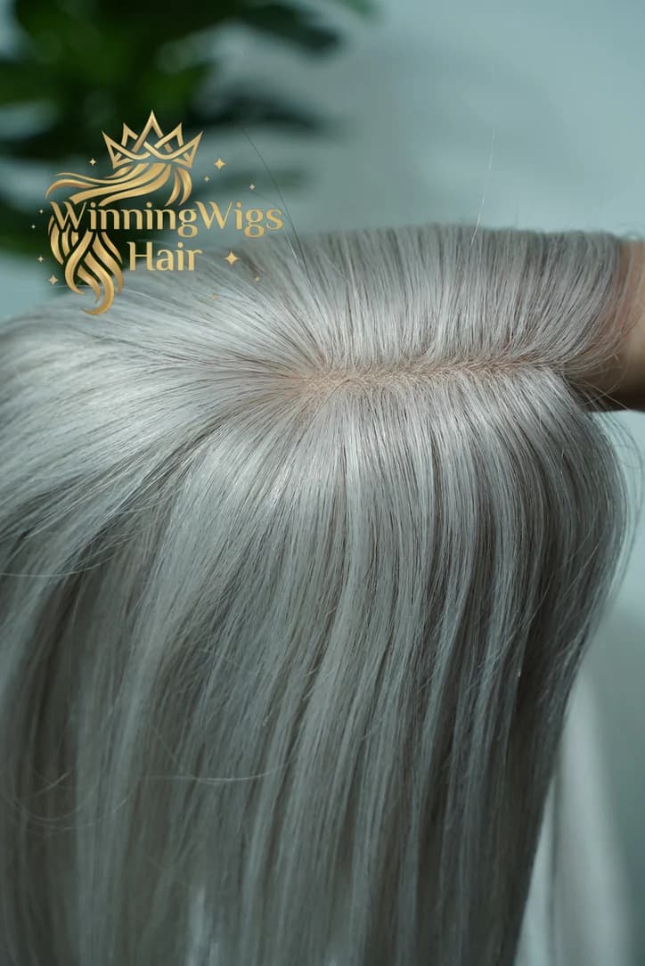 Close view of a gray hairpiece with the hair separated along a visible parting