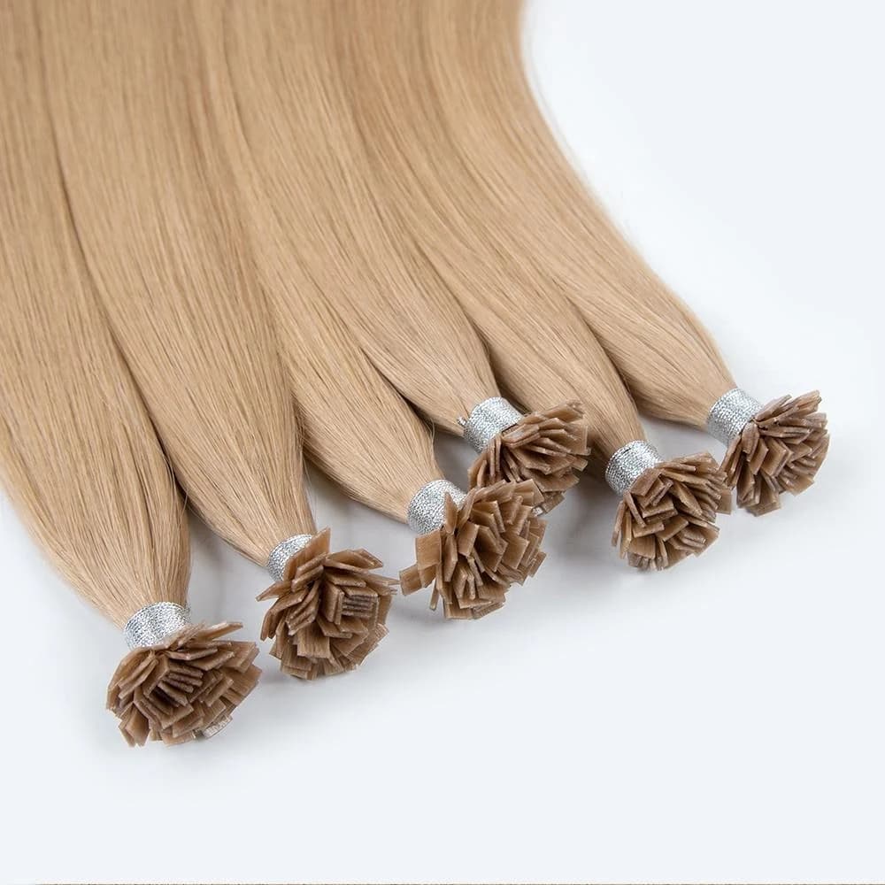 Blonde flat-tip hair extension bundles arranged on white with their flat bond ends visible