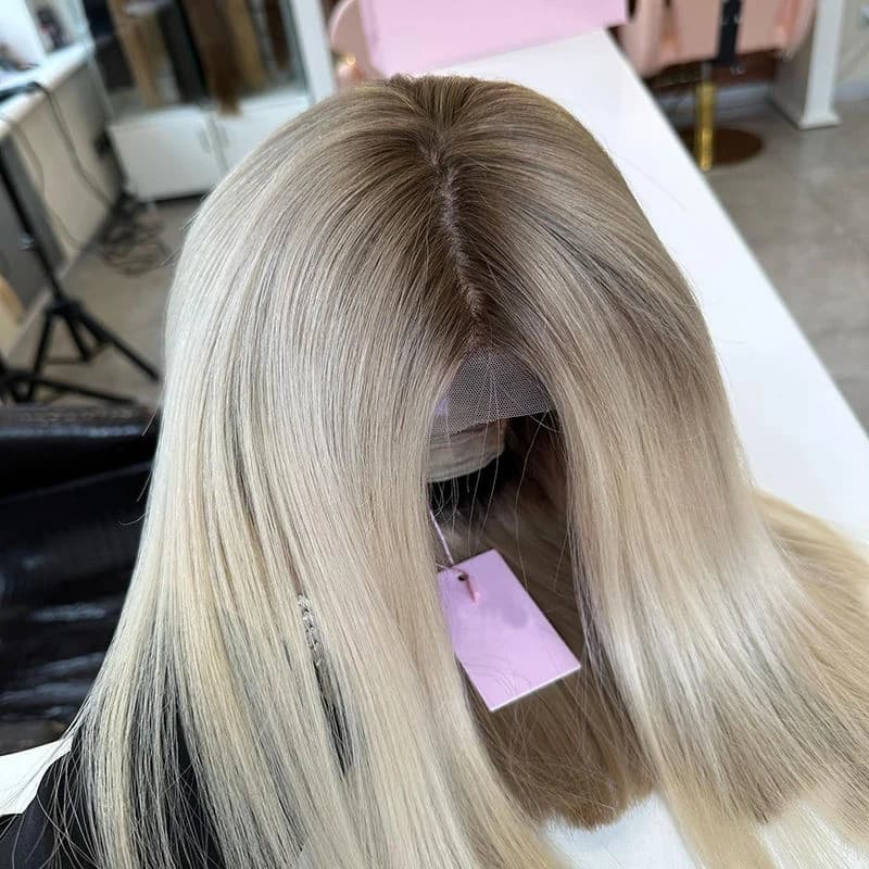 Rooted light blonde bob on a display stand with a center part and untrimmed front lace